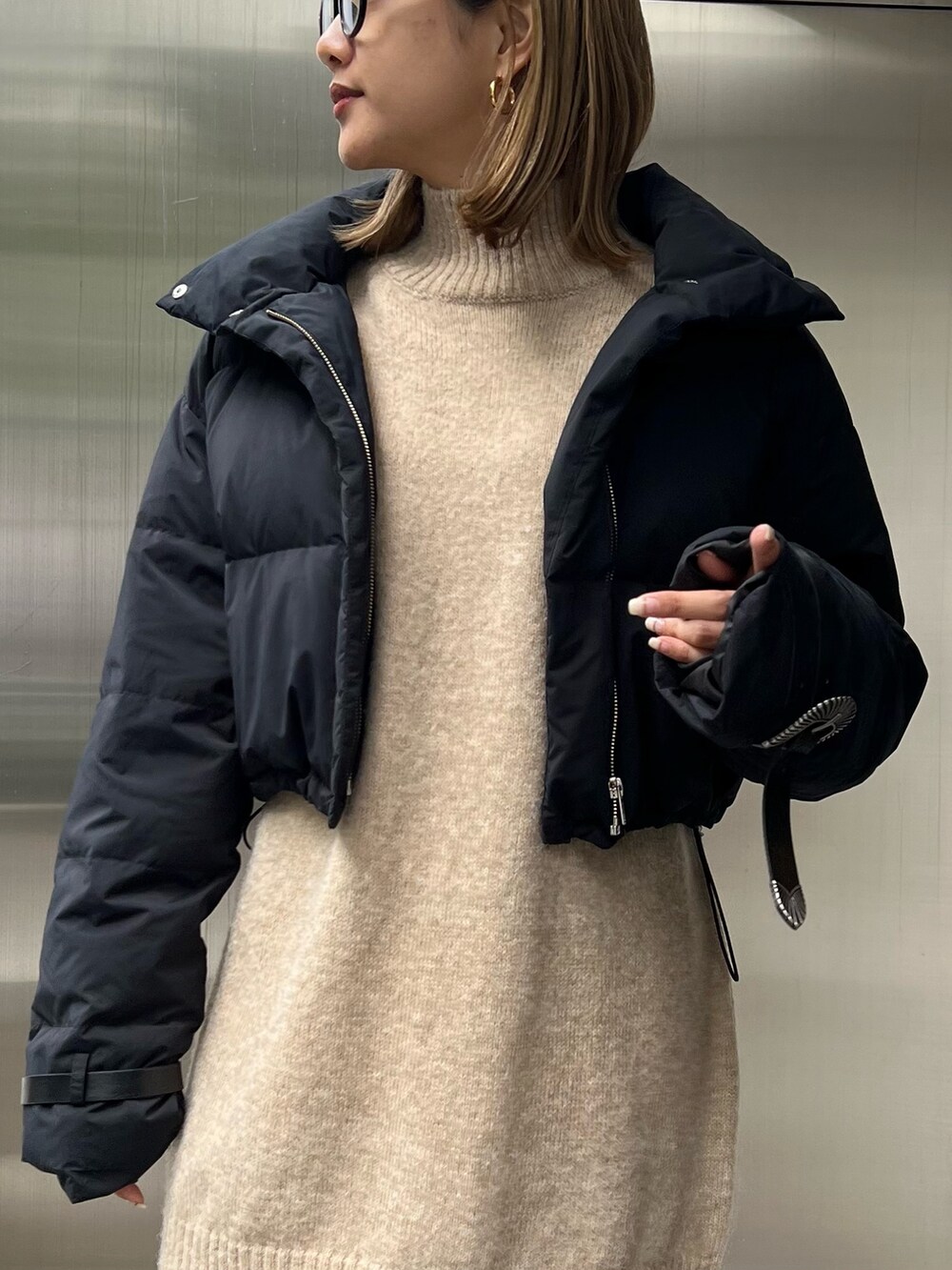 ベージュ系のワンピース、ブラック系のダウンジャケット/コート、ブラック系のブーツを着用したレディースの秋コーディネートの4枚目の写真