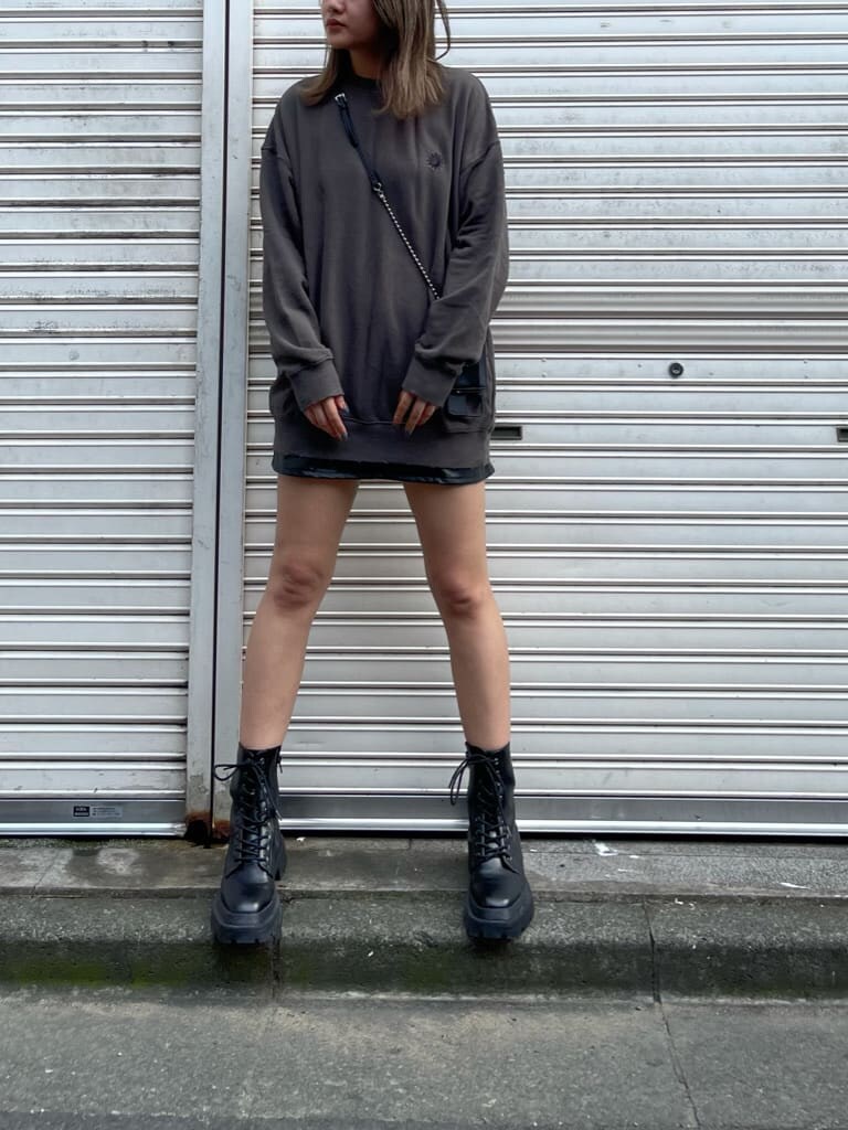 ブラック系のスカート、ブラック系のスウェット、ブラック系のブーツを着用したレディースの夏コーディネートの3枚目の写真