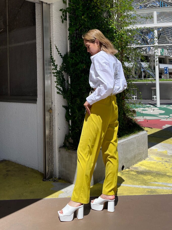 ホワイト系のサンダル、ホワイト系のシャツ/ブラウス、イエロー系のスラックスを着用したレディースの夏コーディネートの3枚目の写真