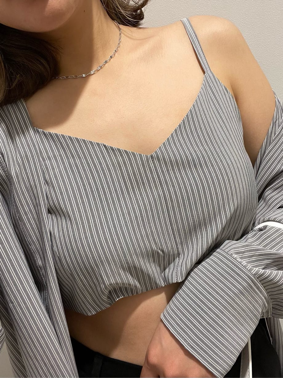 ブラック系のスラックス、ブラック系のワンピース、ホワイト系のショルダーバッグを着用したレディースの春コーディネートの5枚目の写真