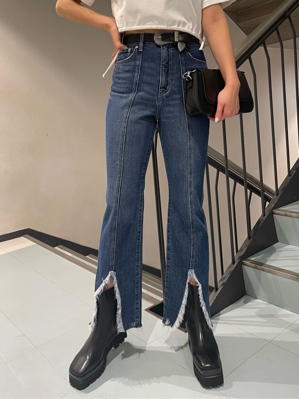 ホワイト系のTシャツ/カットソー、ブラック系のブーツ、ブルー系のデニムパンツを着用したレディースの春コーディネートの6枚目の写真