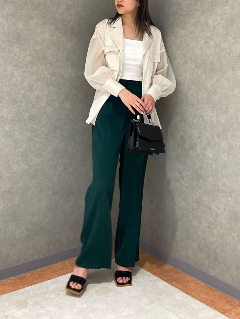 ホワイト系のタンクトップ、グリーン系のスラックス、ホワイト系のシャツ/ブラウスを着用したレディースの春コーディネートの5枚目の写真