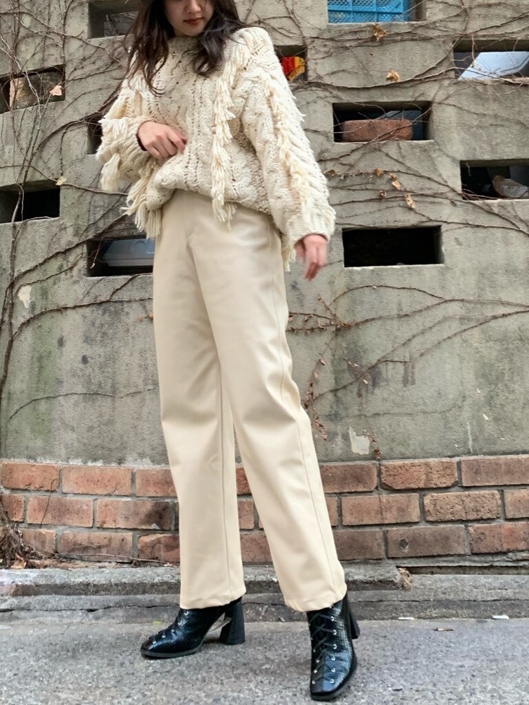 ブラック系のブーツ、ホワイト系のその他パンツを着用したレディースの冬コーディネートの2枚目の写真