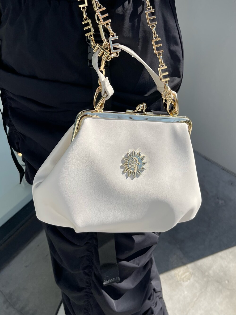 ホワイト系のブーツ、グレー系のスウェット、ホワイト系のショルダーバッグを着用したレディースの春コーディネートの7枚目の写真