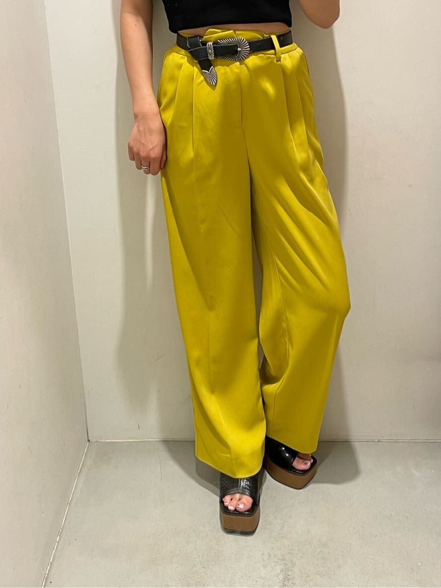 イエロー系のスラックス、ブラック系のタンクトップ、ブラック系のサンダルを着用したレディースの春コーディネートの4枚目の写真