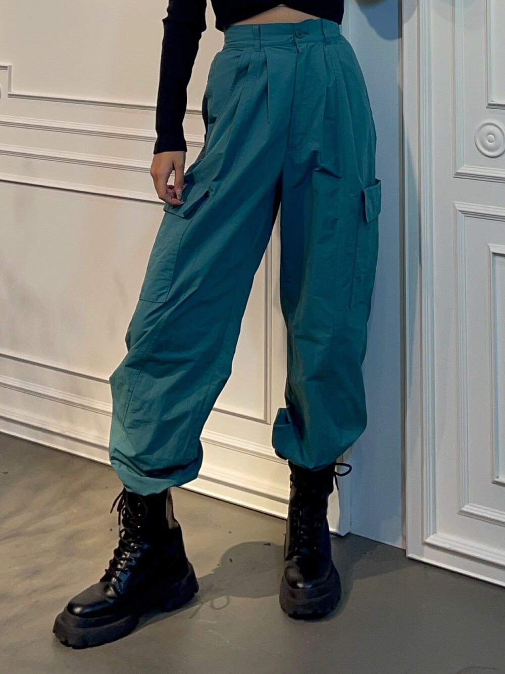 ブルー系のカーゴパンツ、ブラック系のブーツ、ブラック系のTシャツ/カットソーを着用したレディースの秋コーディネートの4枚目の写真