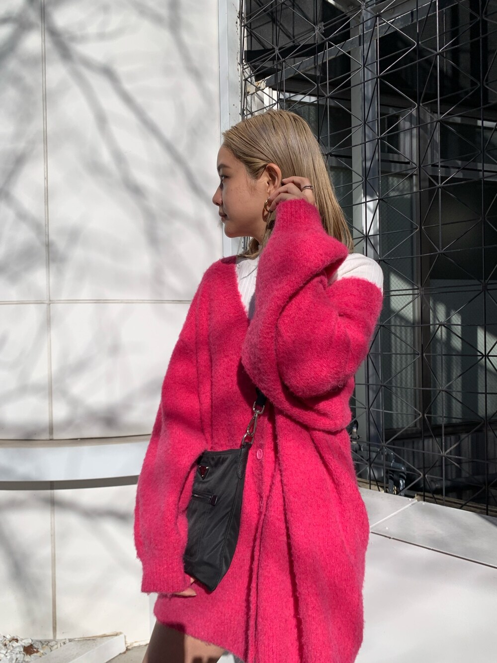 ピンク系のカーディガン/ボレロ、ホワイト系のTシャツ/カットソー、ブラック系のブーツを着用したレディースの冬コーディネートの5枚目の写真