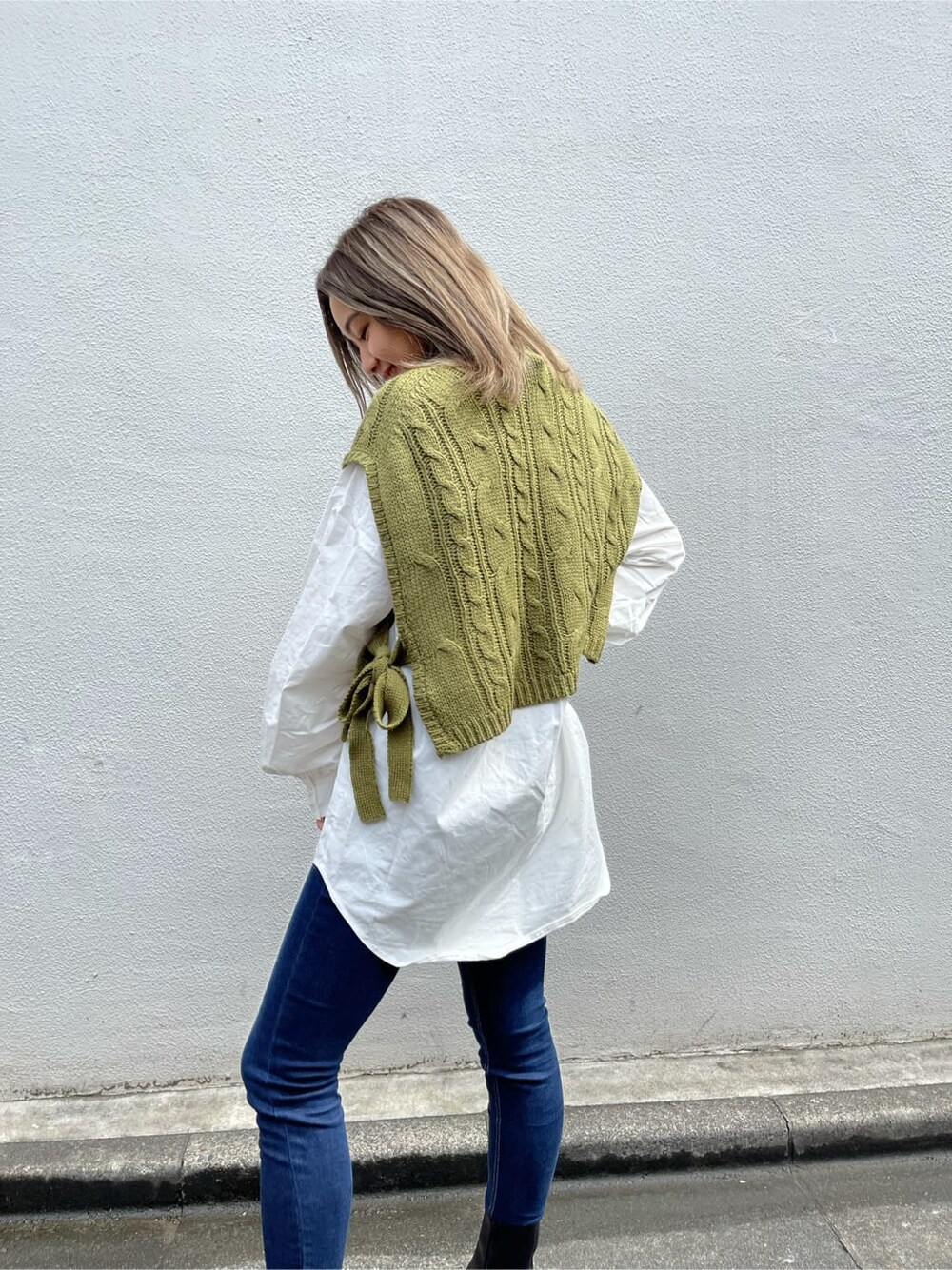 ブルー系のデニムパンツ、ブラック系のブーツ、ホワイト系のシャツ/ブラウスを着用したレディースの秋コーディネートの5枚目の写真