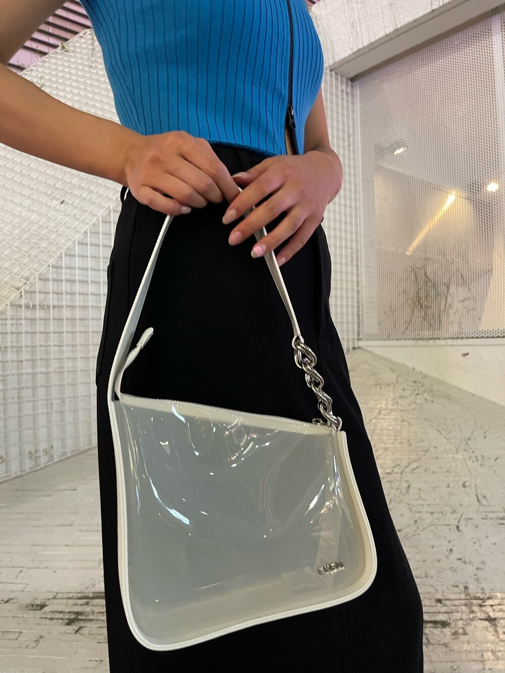 ブラック系のブーツ、ホワイト系のハンドバッグ、ブルー系のタンクトップを着用したレディースの夏コーディネートの8枚目の写真