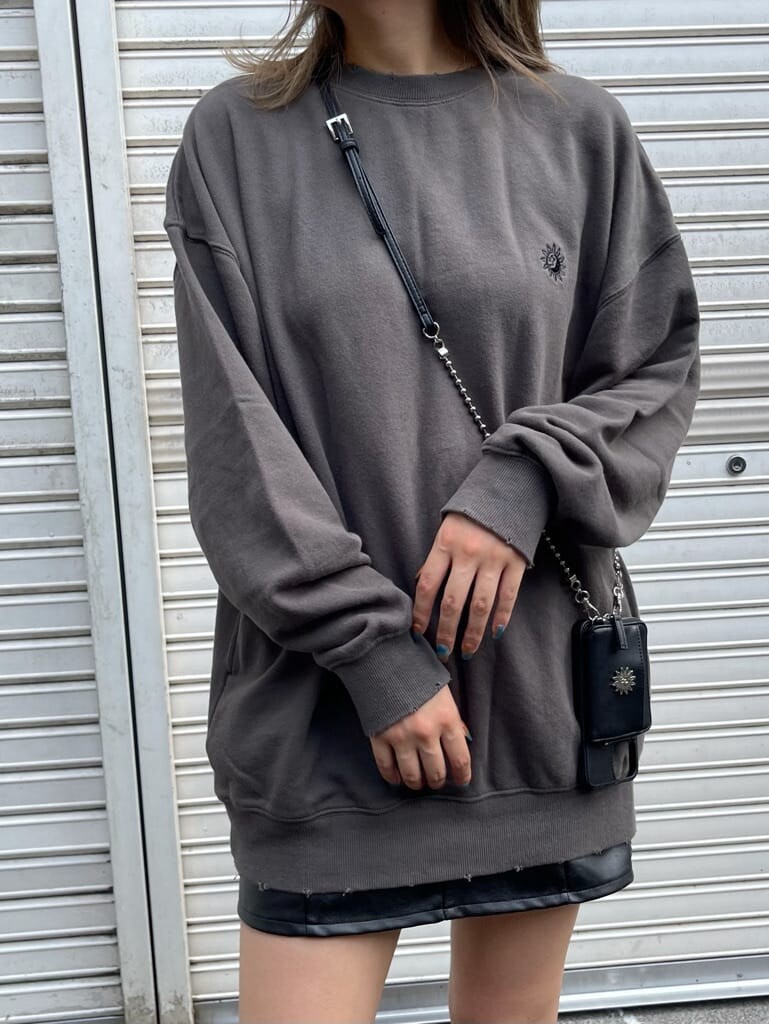 ブラック系のスカート、ブラック系のスウェット、ブラック系のブーツを着用したレディースの夏コーディネートの4枚目の写真