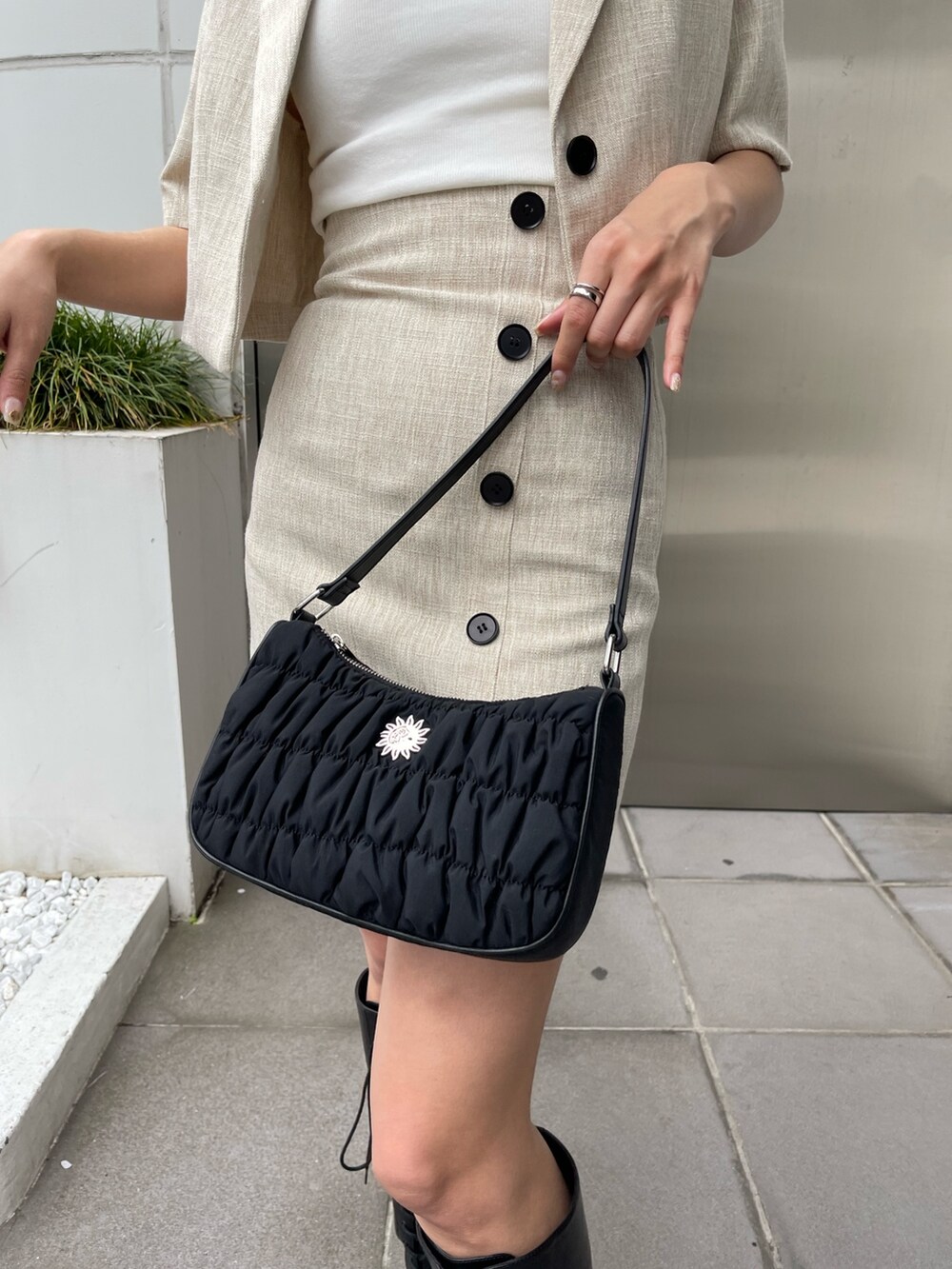 ブラック系のブーツ、ホワイト系のニット/セーター、ホワイト系のテーラードジャケットを着用したレディースの春コーディネートの9枚目の写真