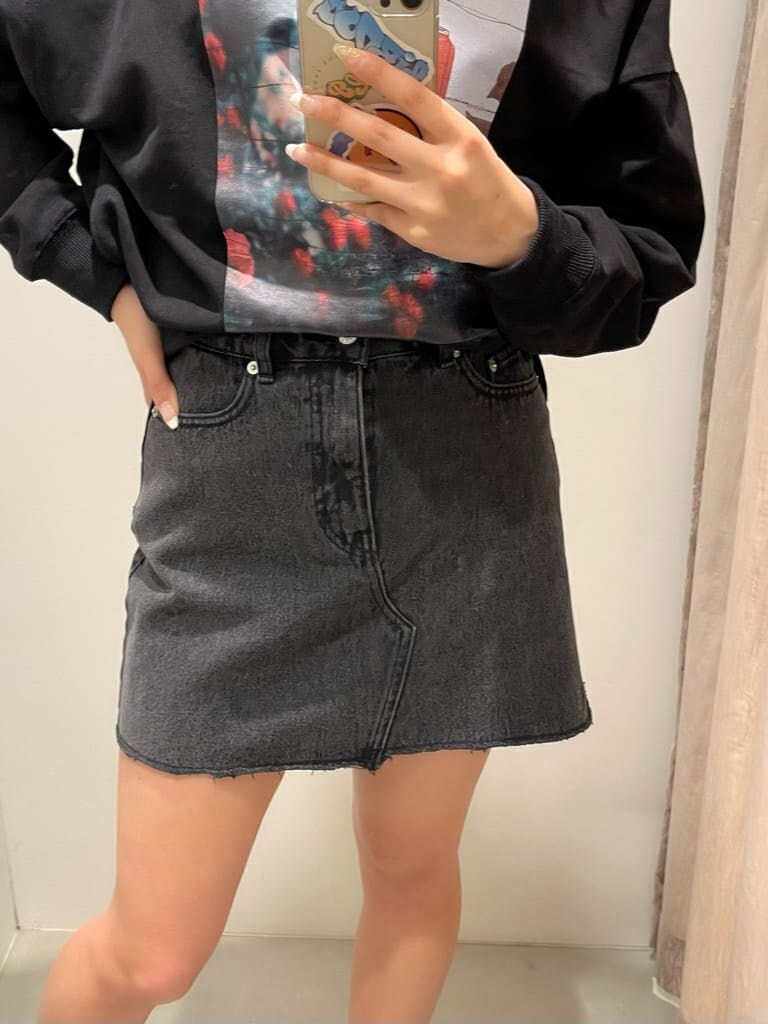 ブラック系のブーツ、ブラック系のデニムスカート、ブラック系のスウェットを着用したレディースの冬コーディネートの5枚目の写真