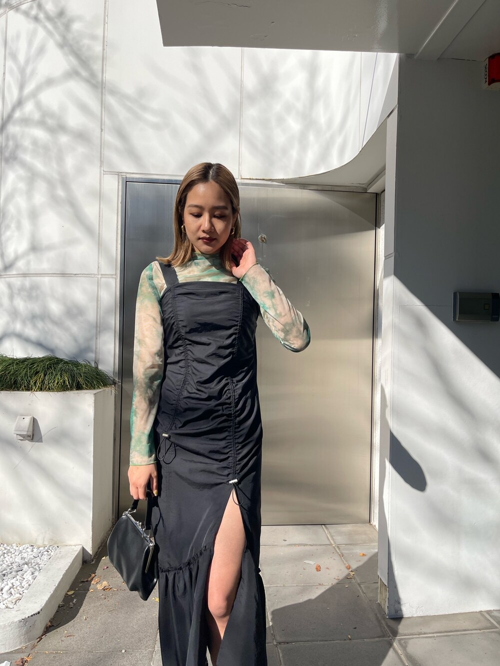 ブラック系のワンピース、ブラック系のショルダーバッグ、ブラック系のブーツを着用したレディースの冬コーディネートの4枚目の写真