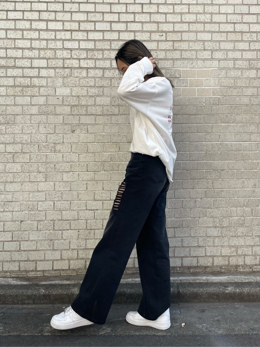 ブラック系のデニムパンツ、ホワイト系のTシャツ/カットソー、ホワイト系のベルトを着用したレディースの冬コーディネートの2枚目の写真