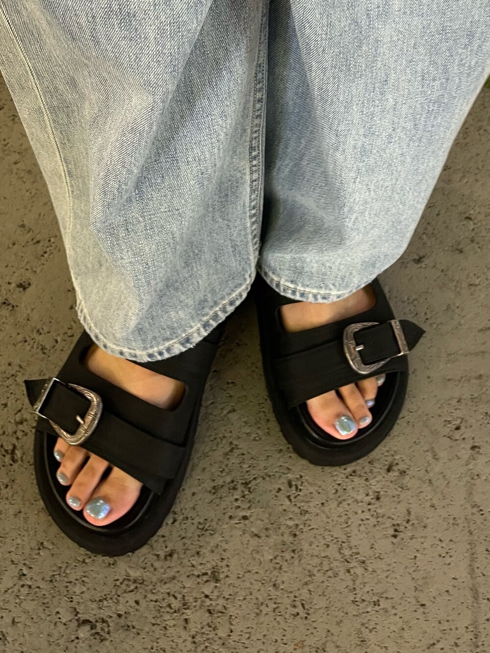 ブルー系のデニムパンツ、ブラック系のTシャツ/カットソー、ブラック系のサンダルを着用したレディースの夏コーディネートの10枚目の写真