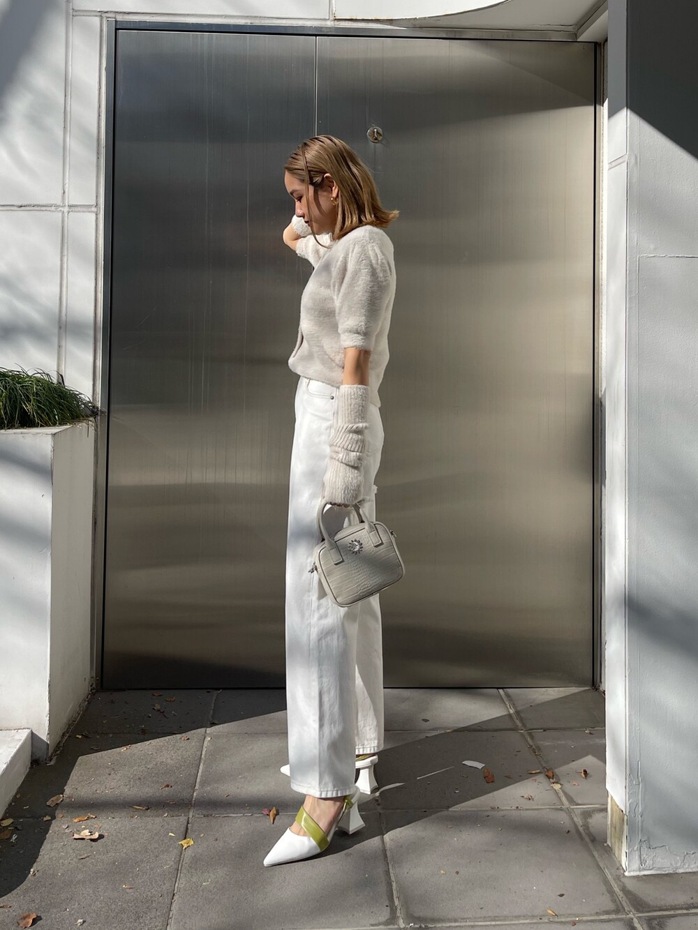 ホワイト系のショルダーバッグ、ホワイト系のサンダル、ホワイト系のニット/セーターを着用したレディースの冬コーディネートの3枚目の写真