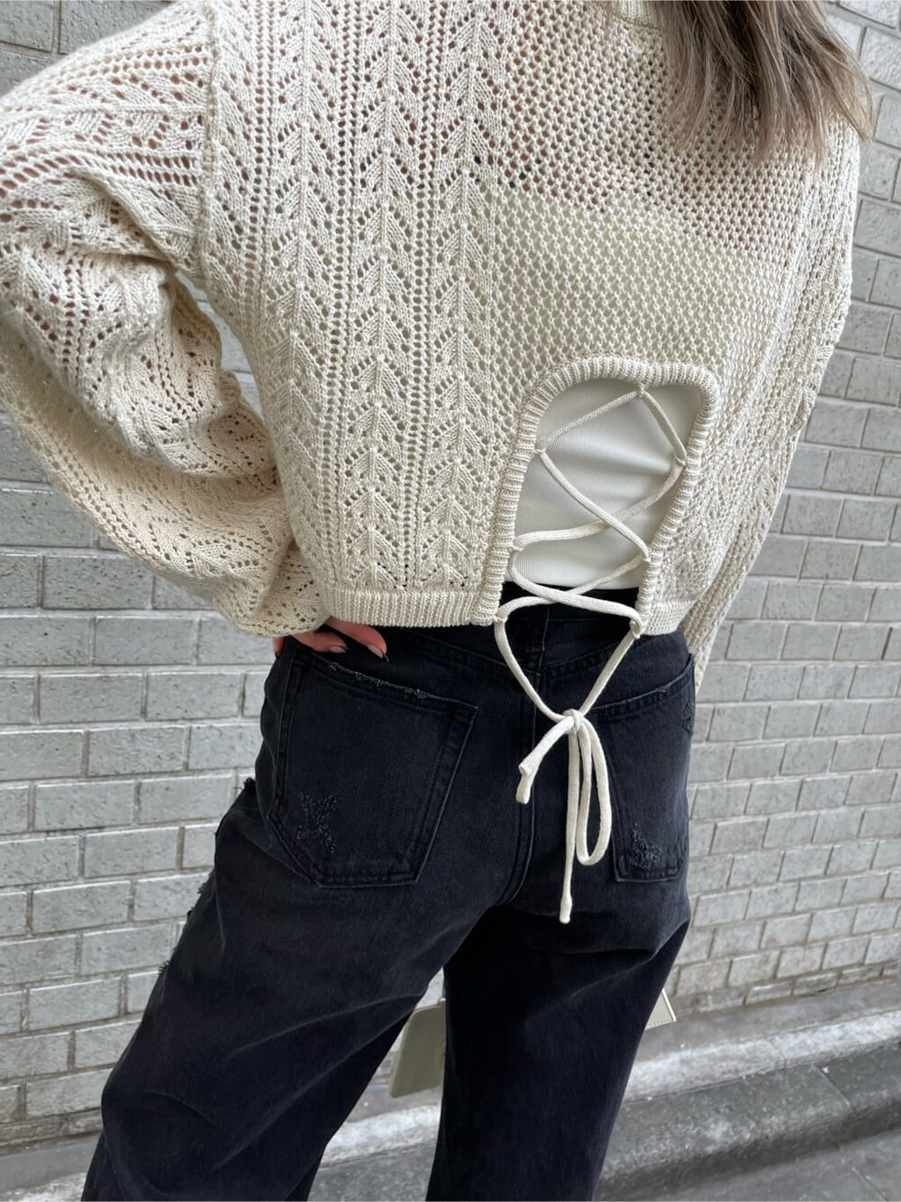 ブラック系のデニムパンツ、ホワイト系のキャミソール、ホワイト系のショルダーバッグを着用したレディースの春コーディネートの5枚目の写真