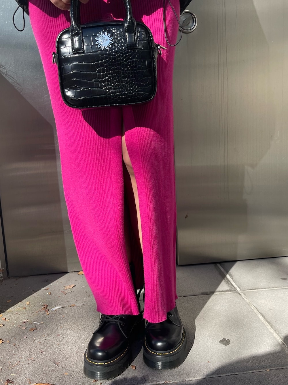 ブラック系のワンピース、ブラック系のショルダーバッグ、ブラック系のダウンジャケット/コートを着用したレディースの冬コーディネートの5枚目の写真