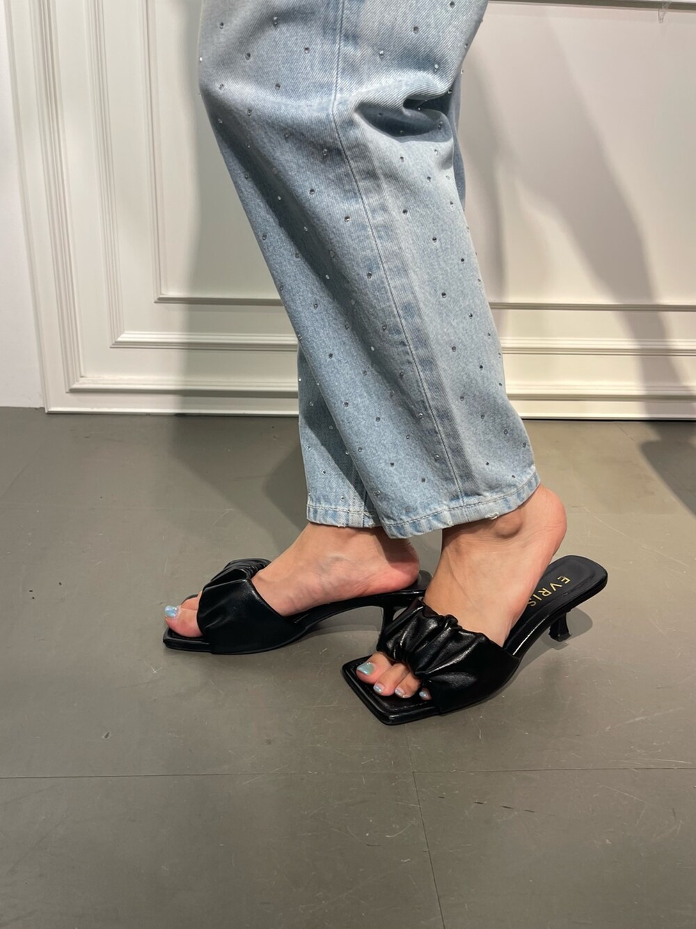 ブルー系のデニムパンツ、ブラック系のサンダル、ホワイト系のTシャツ/カットソーを着用したレディースの夏コーディネートの7枚目の写真