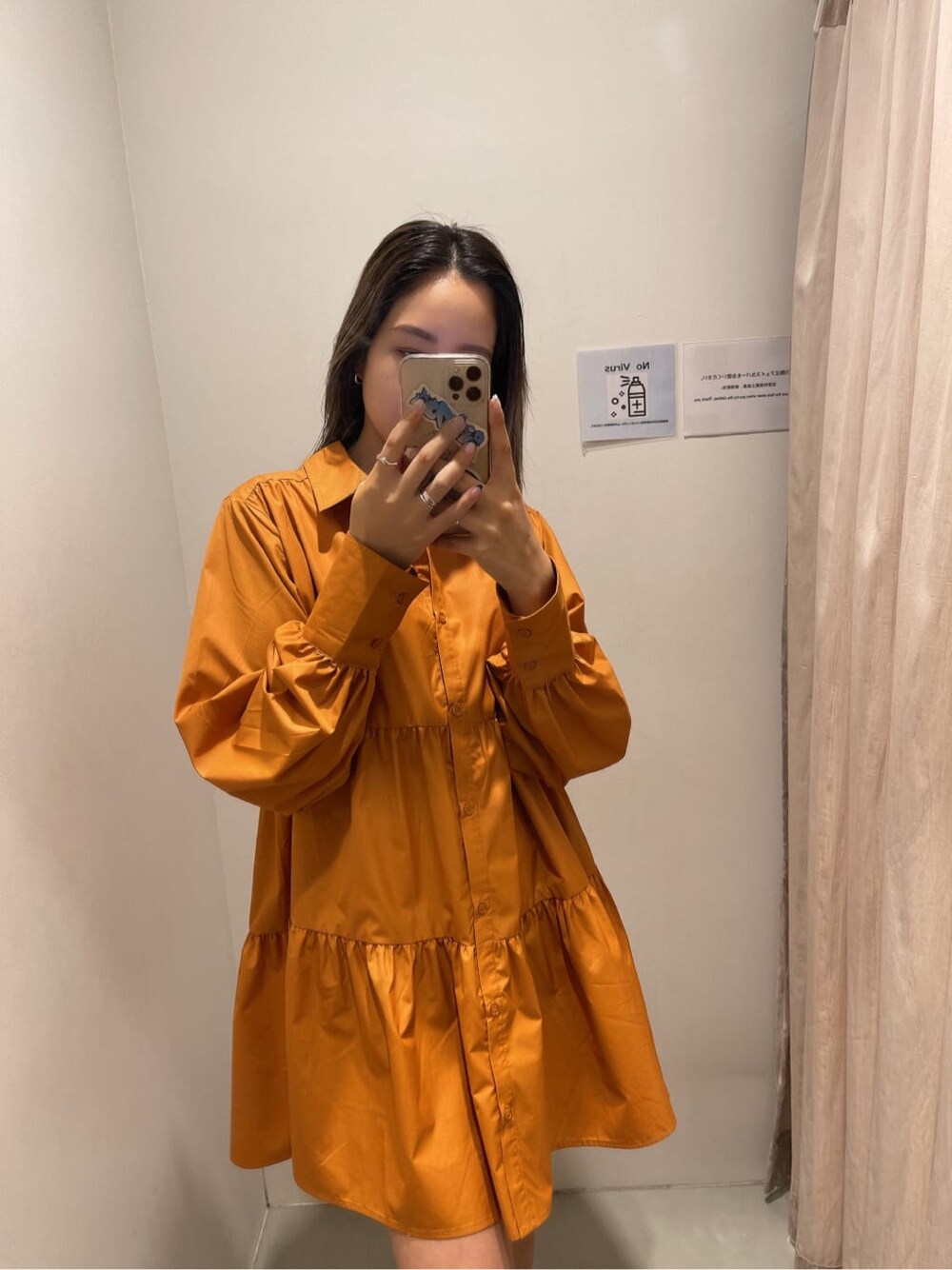 オレンジ系のシャツワンピース、ブラック系のブーツ、ブラック系のショルダーバッグを着用したレディースの冬コーディネートの4枚目の写真