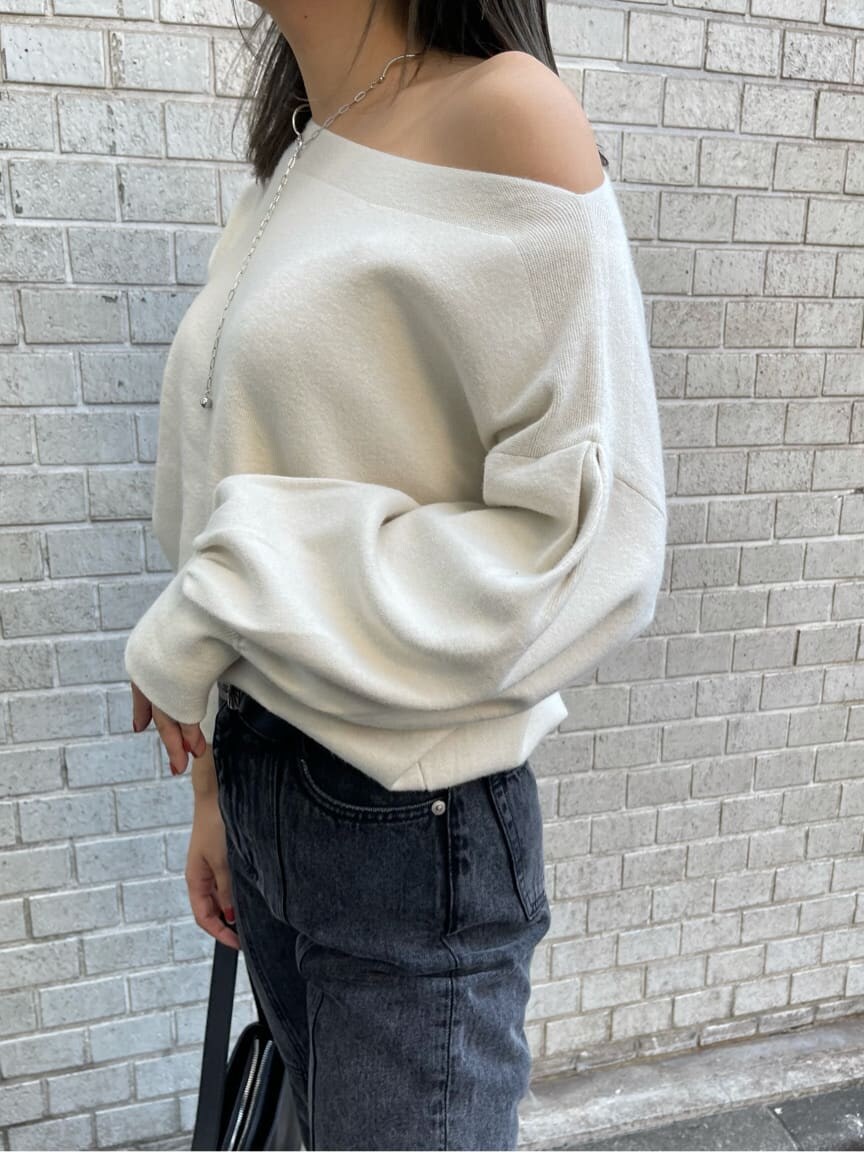 ブラック系のショルダーバッグ、ブラック系のデニムパンツ、ホワイト系のニット/セーターを着用したレディースの秋コーディネートの6枚目の写真