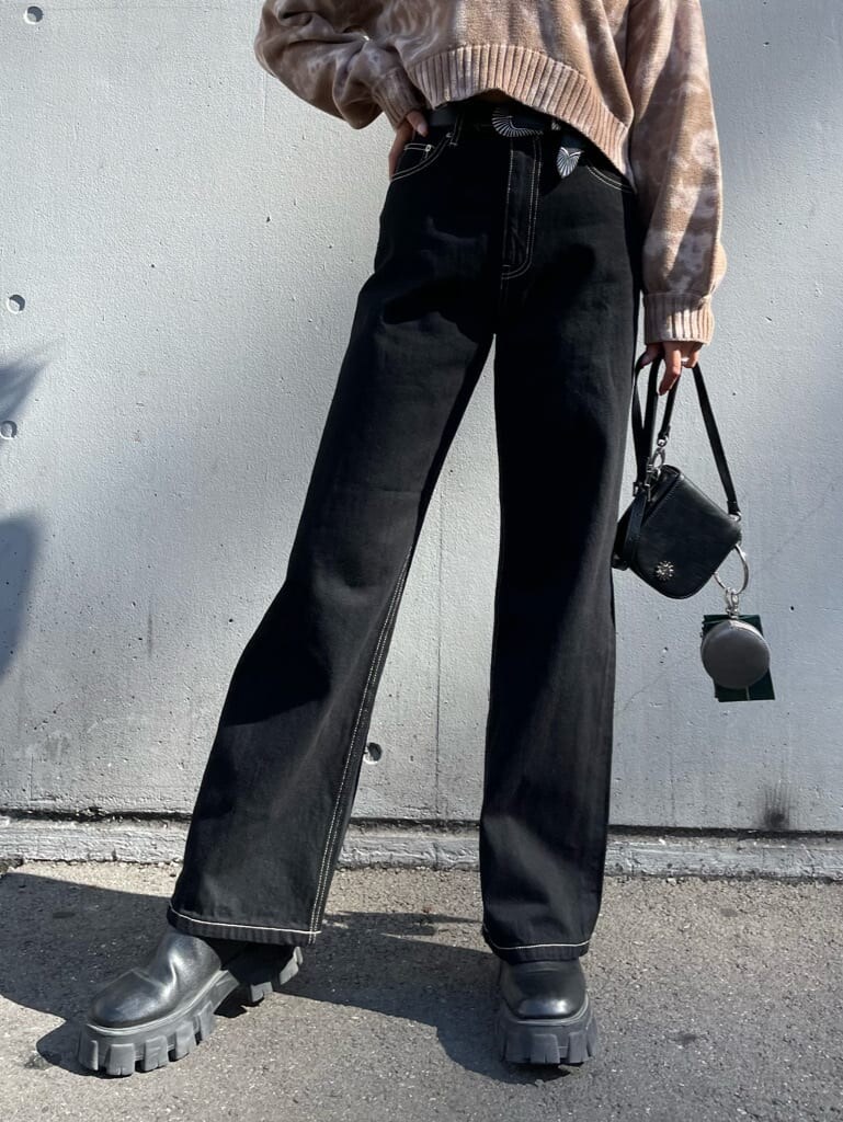 ブラック系のブーツ、ベージュ系のニット/セーター、ブラック系のデニムパンツを着用したレディースの秋コーディネートの5枚目の写真