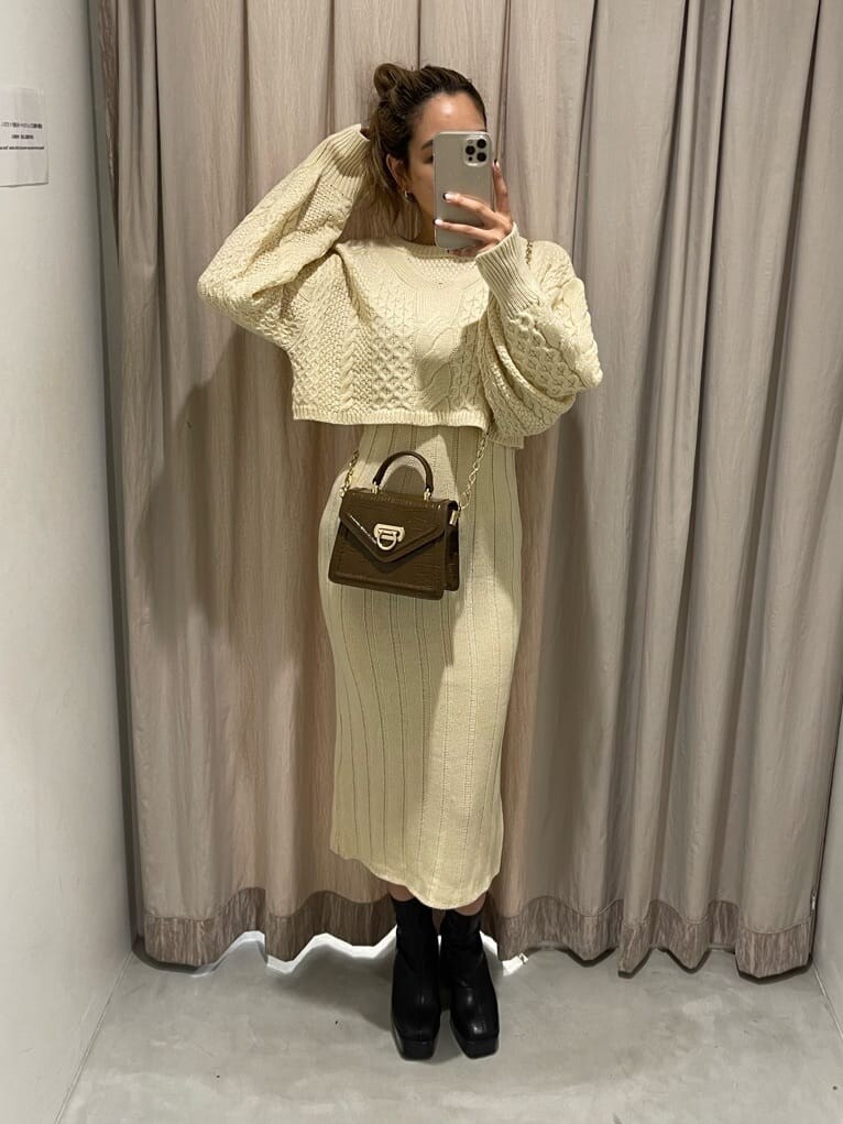 ブラック系のブーツ、ホワイト系のワンピース、ブラウン系のハンドバッグを着用したレディースの秋コーディネートの2枚目の写真