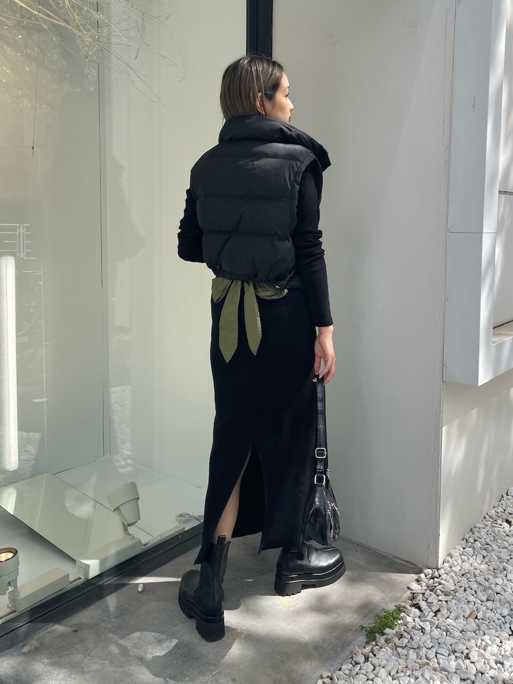 ブラック系のワンピース、ブラック系のブーツ、ブラック系のショルダーバッグを着用したレディースの秋コーディネートの3枚目の写真