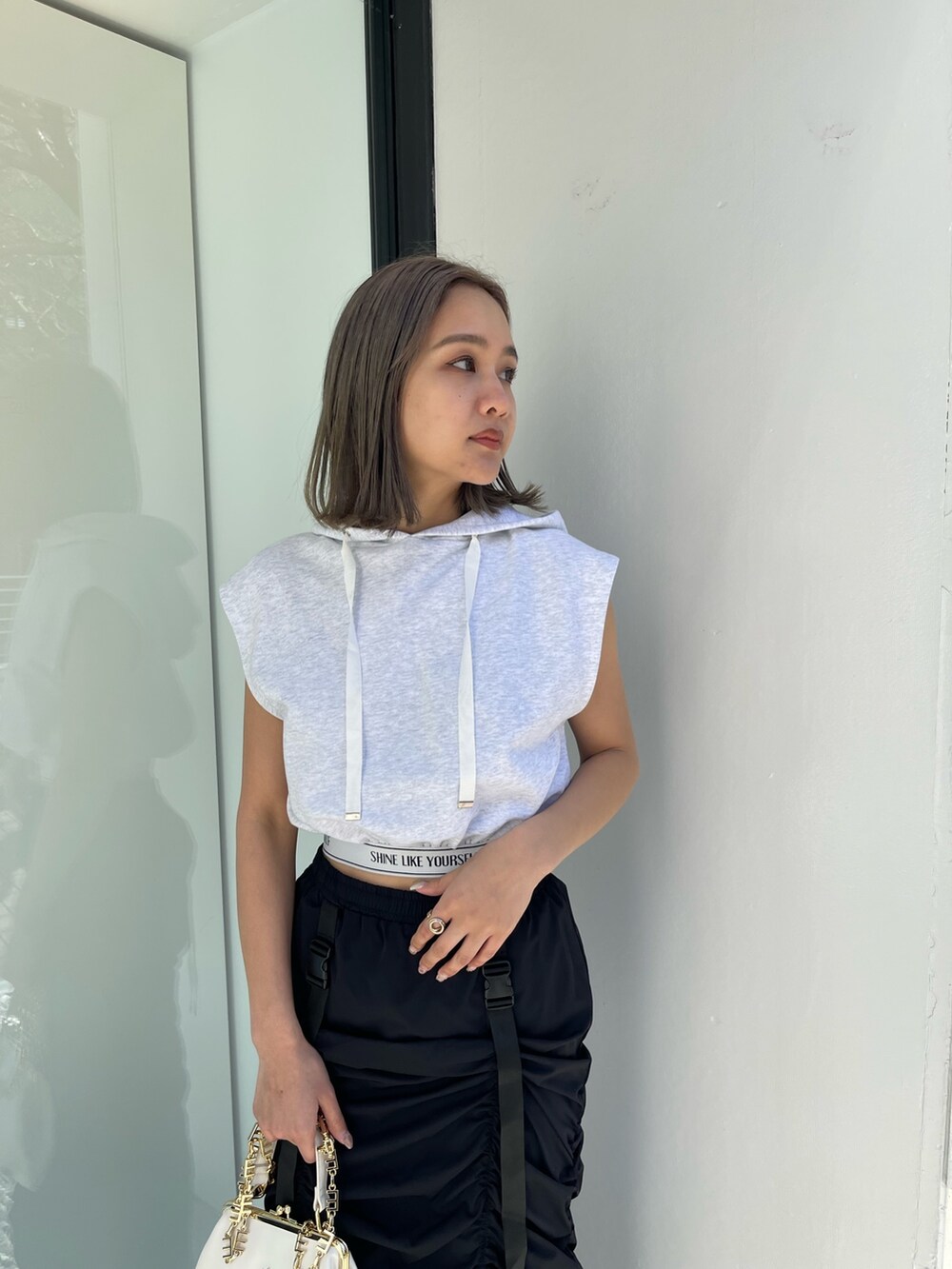 ホワイト系のブーツ、グレー系のスウェット、ホワイト系のショルダーバッグを着用したレディースの春コーディネートの4枚目の写真