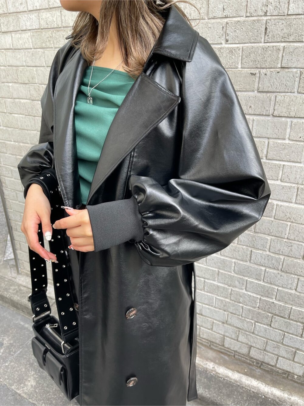 ブラック系のトレンチコート、グリーン系のシャツ/ブラウス、ブラック系のショルダーバッグを着用したレディースの冬コーディネートの7枚目の写真