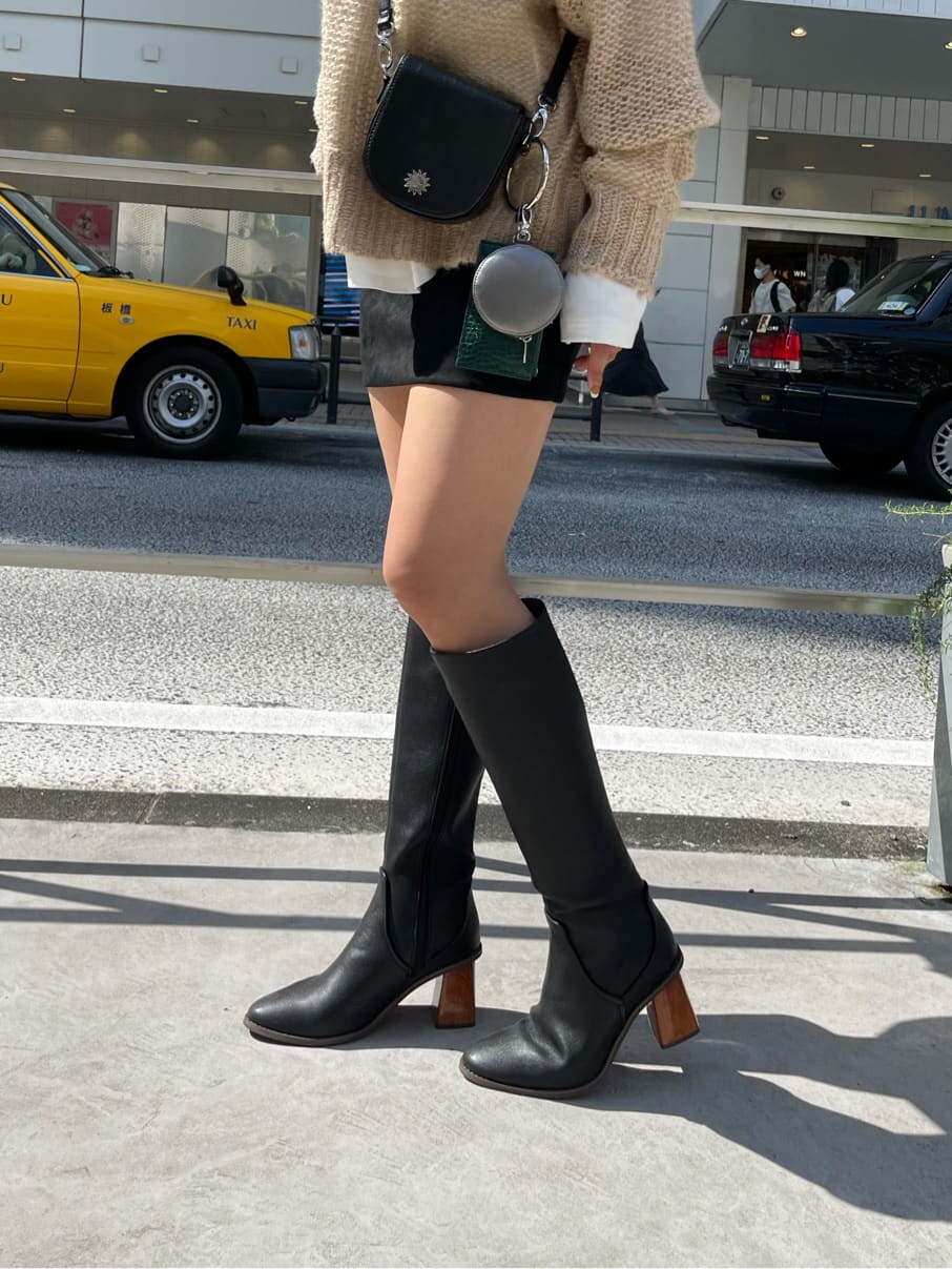 ブラック系のショルダーバッグ、ブラック系のブーツ、その他のニット/セーターを着用したレディースの秋コーディネートの5枚目の写真