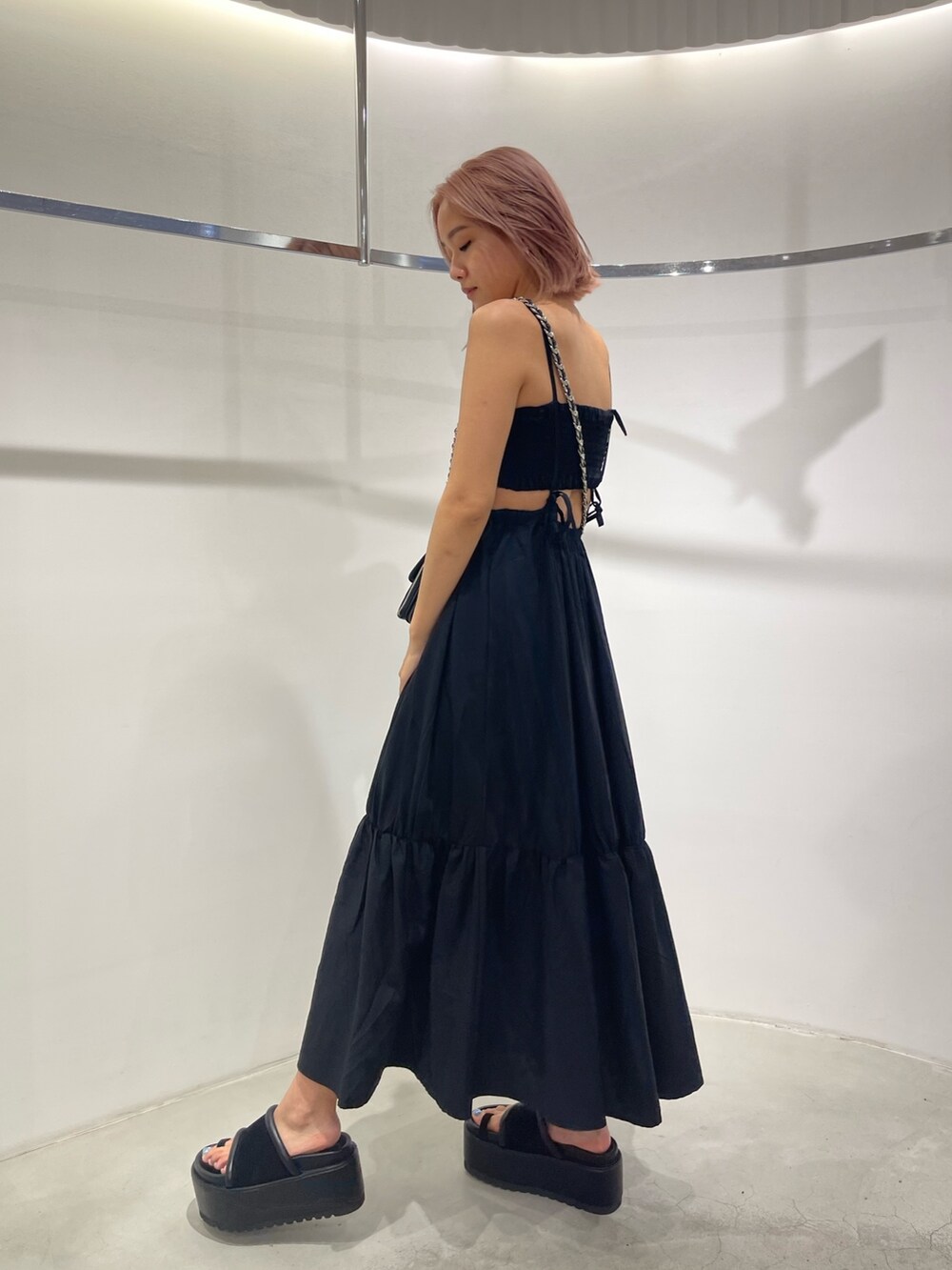 ブラック系のサンダル、ブラック系のショルダーバッグ、ブラック系のワンピースを着用したレディースの夏コーディネートの2枚目の写真