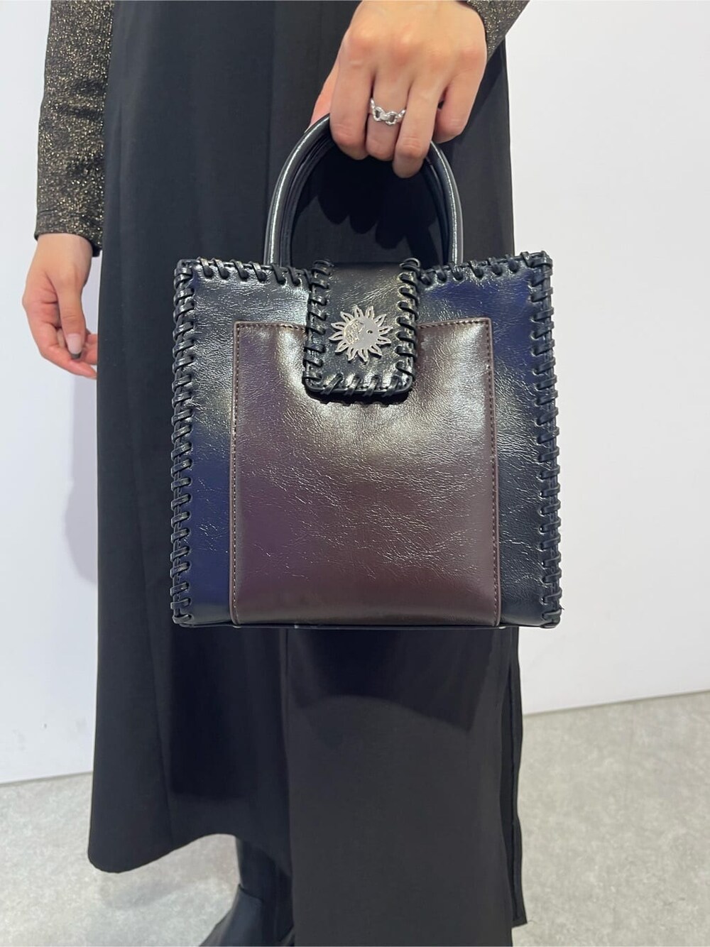 ブラック系のショルダーバッグ、ブラック系のブーツ、ブラウン系のTシャツ/カットソーを着用したレディースの秋コーディネートの7枚目の写真