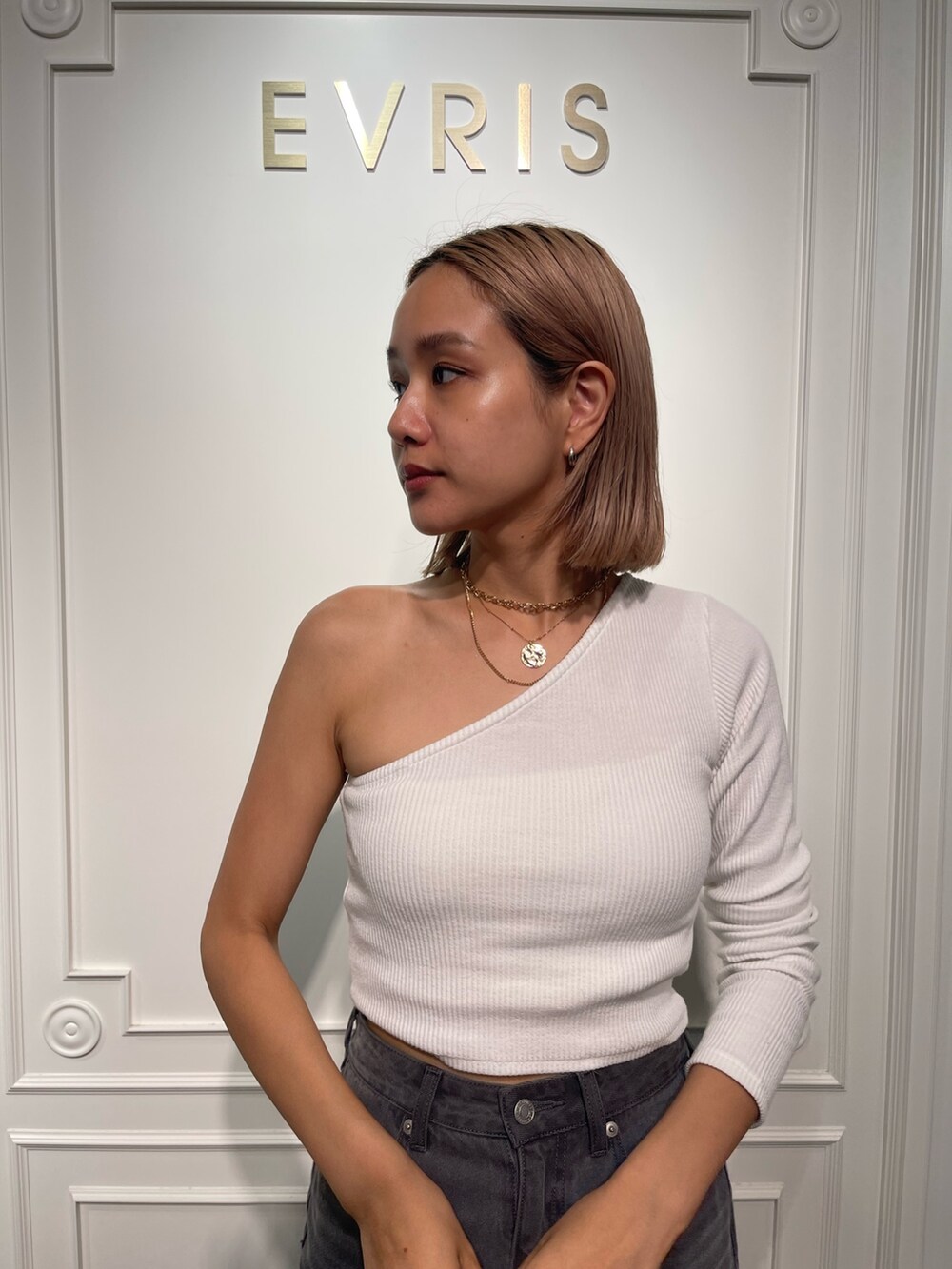 ホワイト系のTシャツ/カットソー、ブラック系のデニムスカート、ブラック系のブーツを着用したレディースの夏コーディネートの6枚目の写真