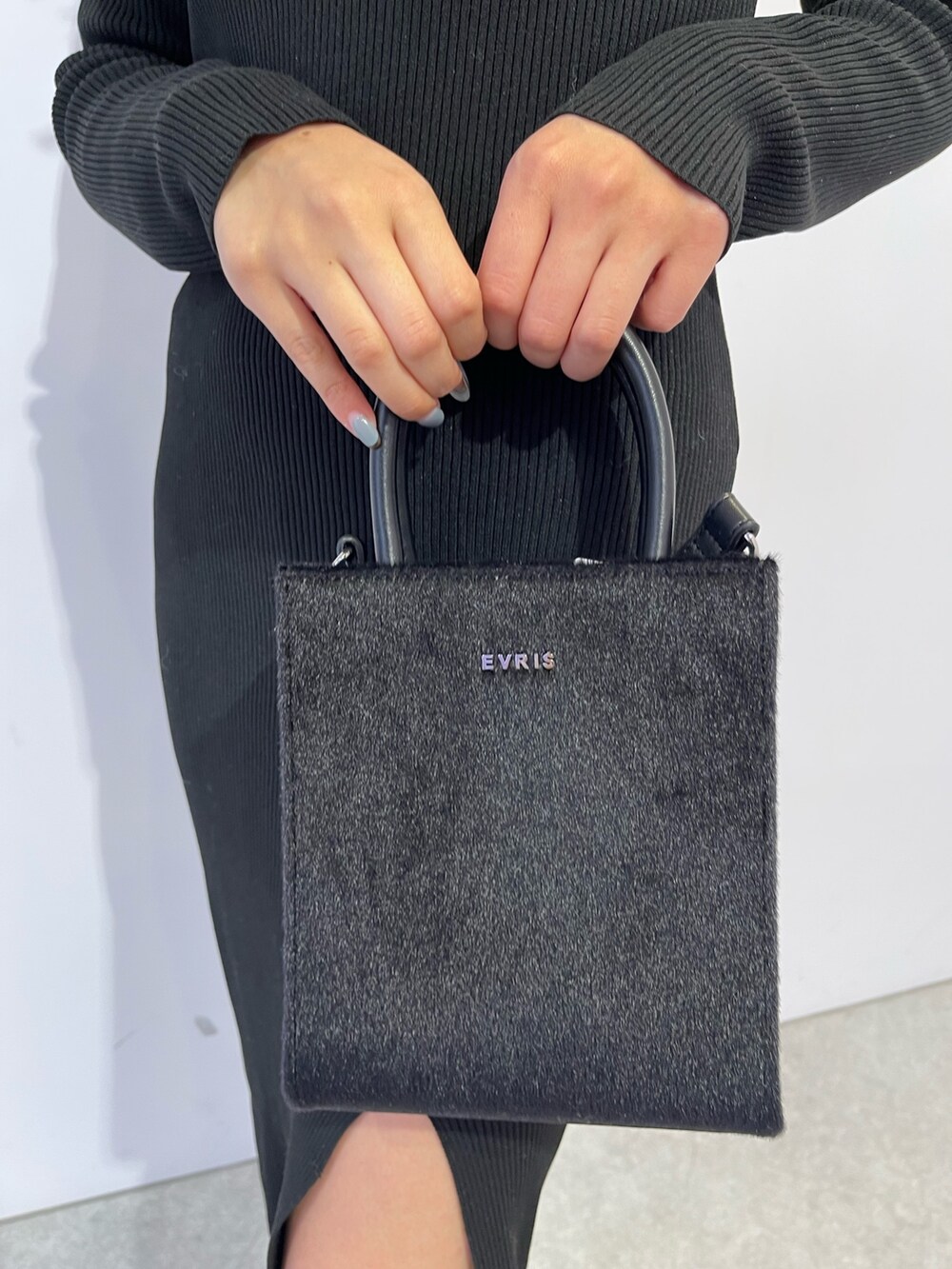 ブラック系のブーツ、ブラック系のショルダーバッグ、ブラック系のワンピースを着用したレディースの冬コーディネートの8枚目の写真