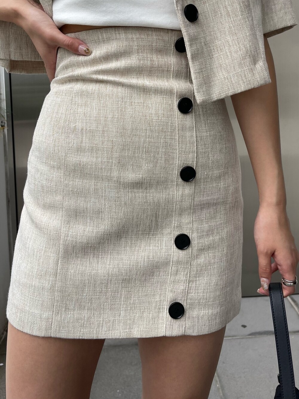 ブラック系のブーツ、ホワイト系のニット/セーター、ホワイト系のテーラードジャケットを着用したレディースの春コーディネートの8枚目の写真