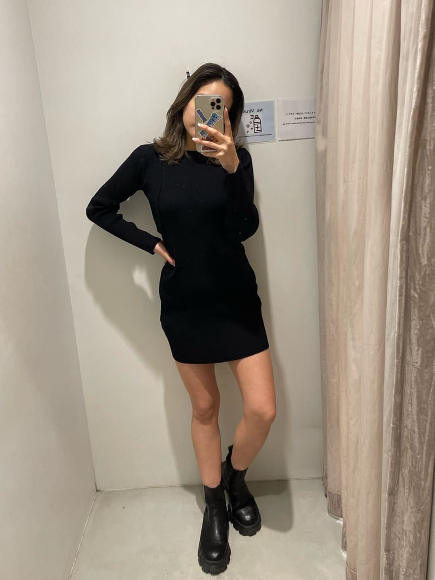 ブラック系のワンピース、ブラック系のブーツ、ホワイト系のブルゾンを着用したレディースの冬コーディネートの3枚目の写真