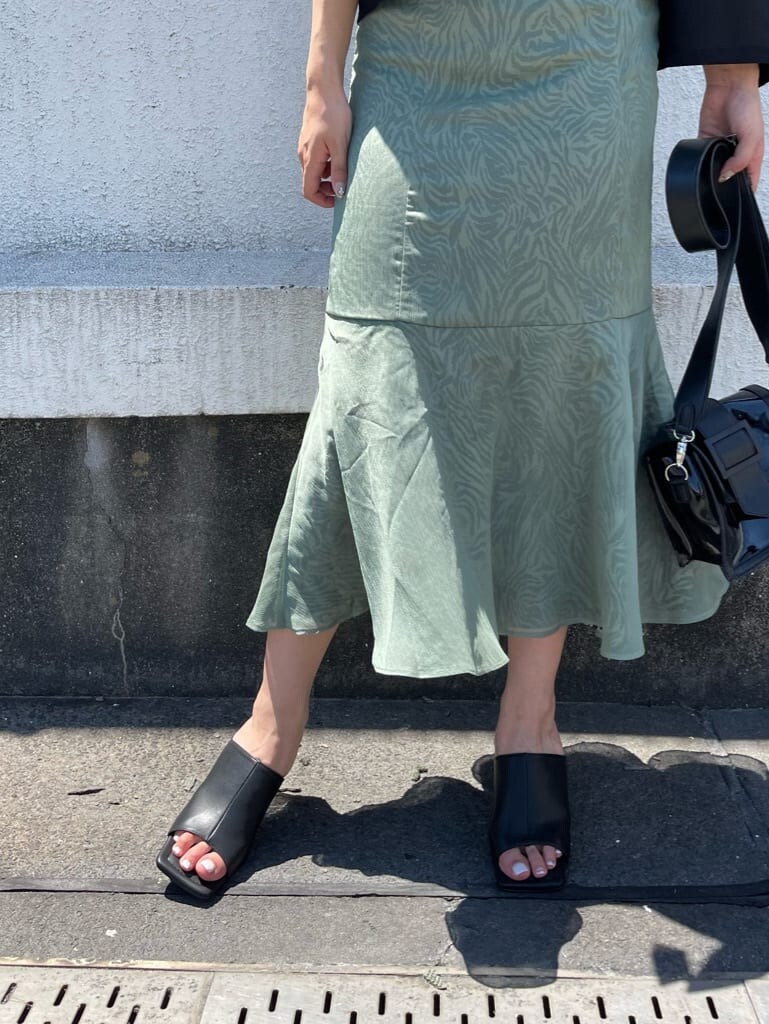 グリーン系のワンピース、ブラック系のサンダル、ブラック系のショルダーバッグを着用したレディースの夏コーディネートの5枚目の写真