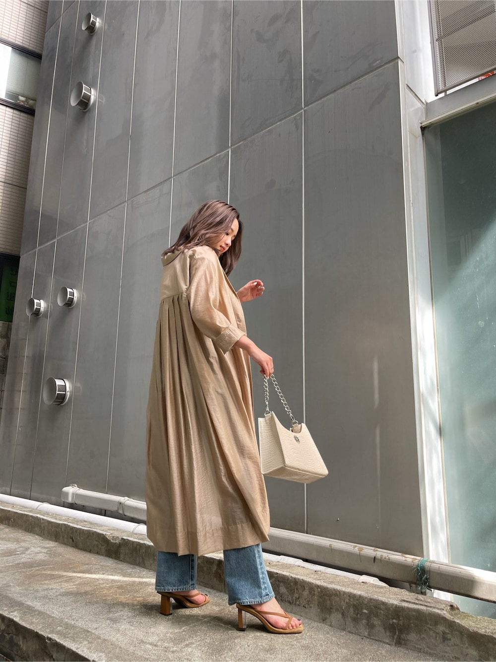 ベージュ系のその他アウター、ブルー系のデニムパンツ、ブラウン系のサンダルを着用したレディースの春コーディネートの4枚目の写真