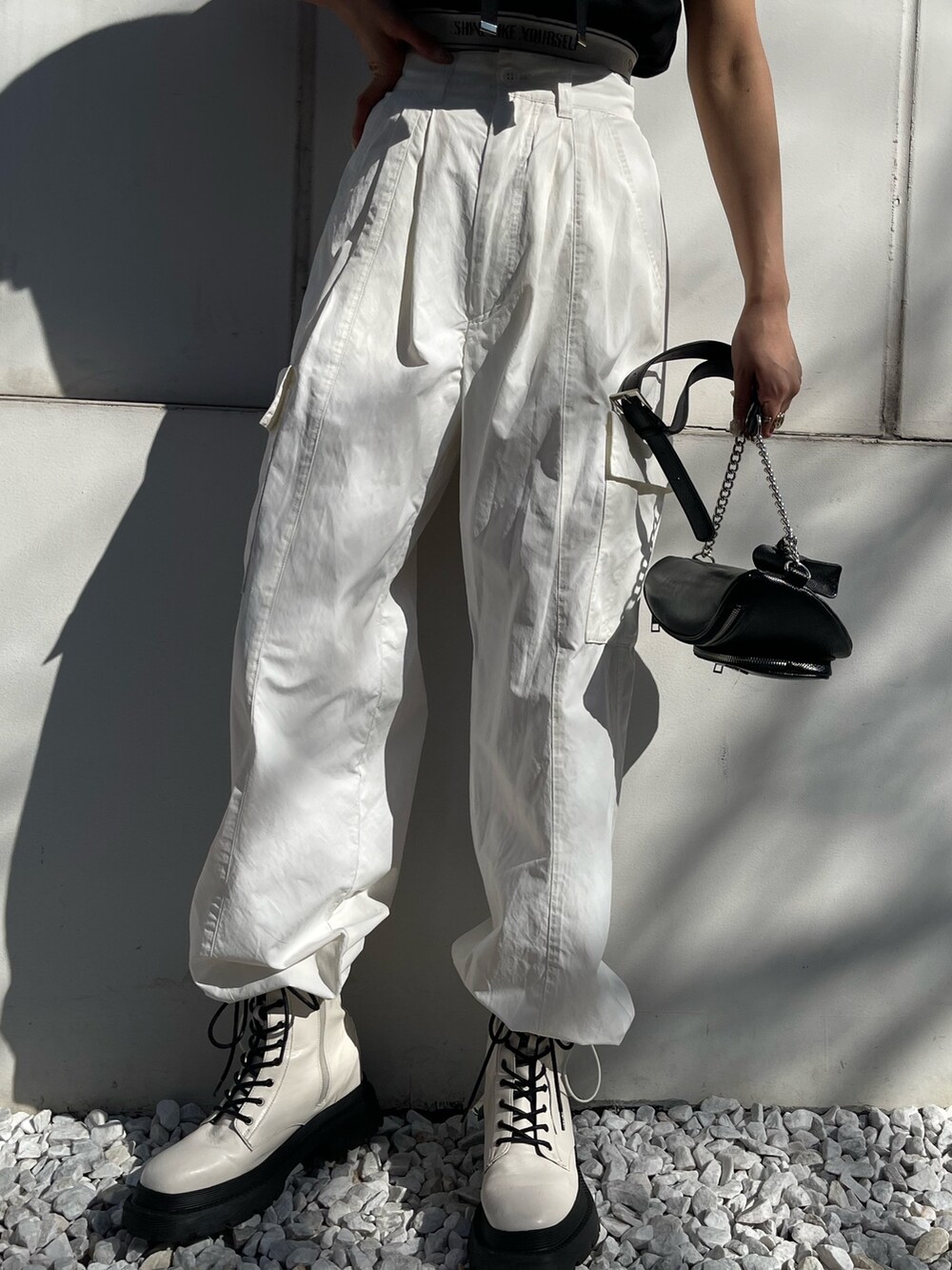 ホワイト系のカーゴパンツ、ブラック系のスウェット、ホワイト系のブーツを着用したレディースの春コーディネートの8枚目の写真