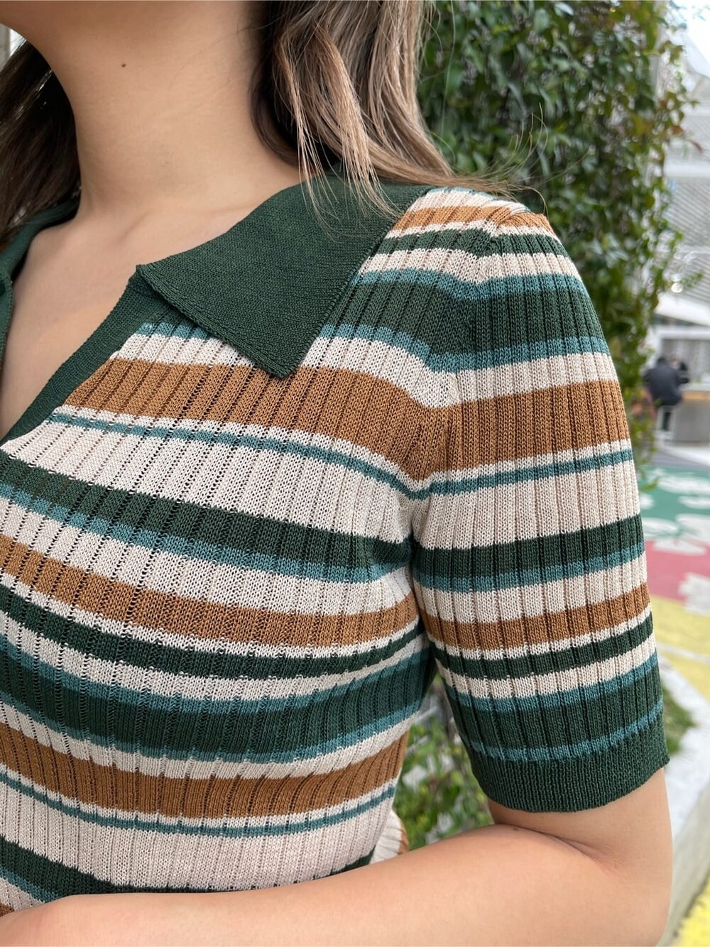 ブラック系のショルダーバッグ、グリーン系のニット/セーター、ブラック系のスラックスを着用したレディースの春コーディネートの5枚目の写真