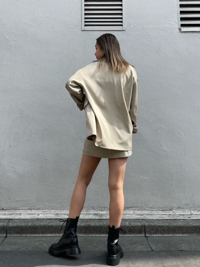 ブラック系のブーツ、ブラック系のキャミソール、ベージュ系のスカートを着用したレディースの春コーディネートの3枚目の写真