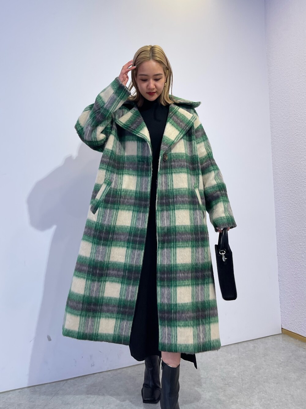 グリーン系のその他アウター、ブラック系のブーツ、ブラック系のワンピースを着用したレディースの冬コーディネートの2枚目の写真