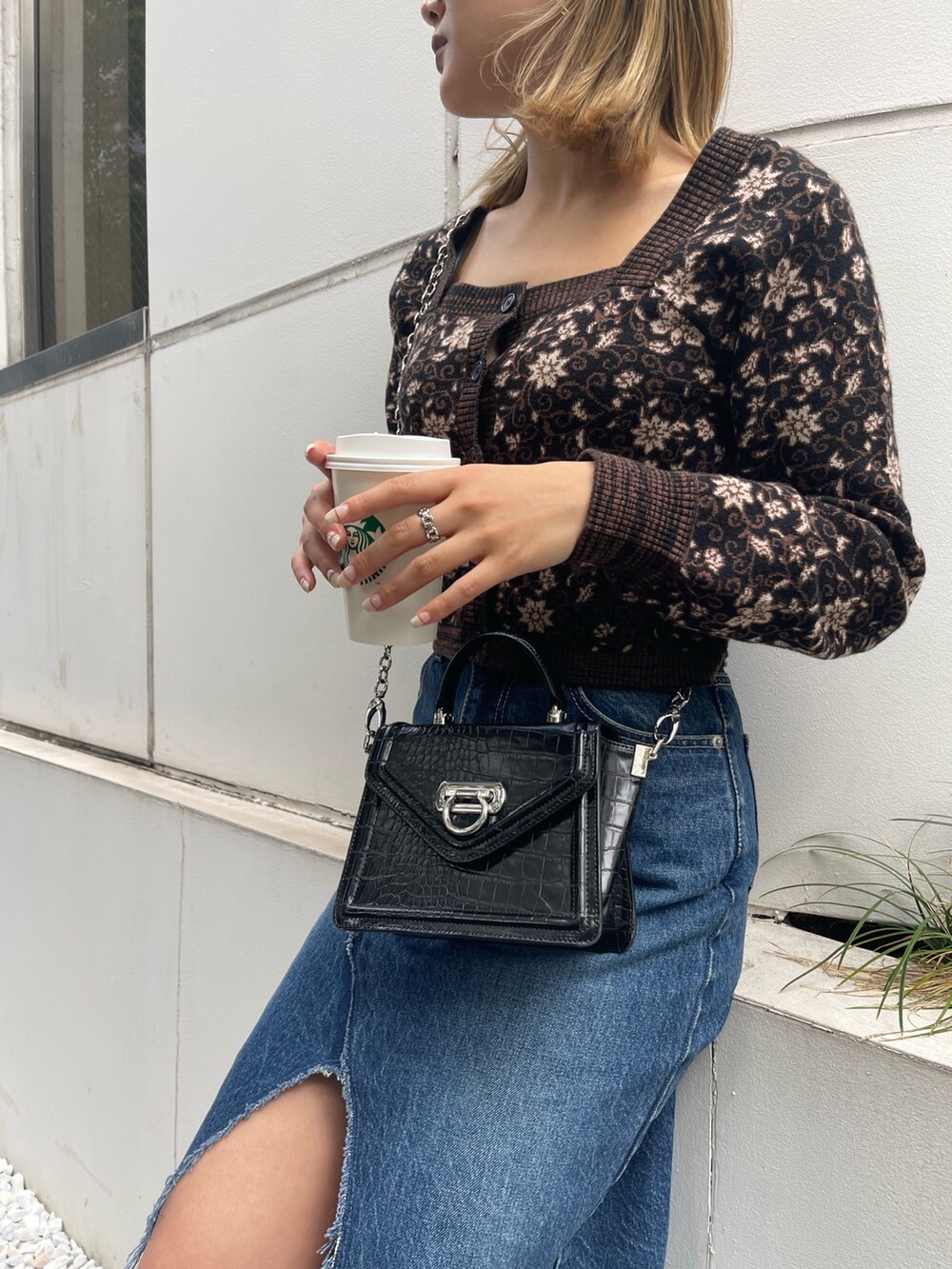 ブルー系のデニムスカート、ブラック系のブーツ、ブラック系のニット/セーターを着用したレディースの秋コーディネートの7枚目の写真