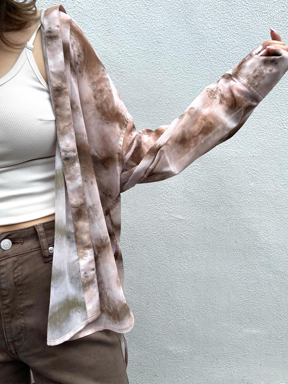 ブラウン系のシャツ/ブラウス、ブラック系のサンダル、ブラウン系のデニムパンツを着用したレディースの夏コーディネートの6枚目の写真