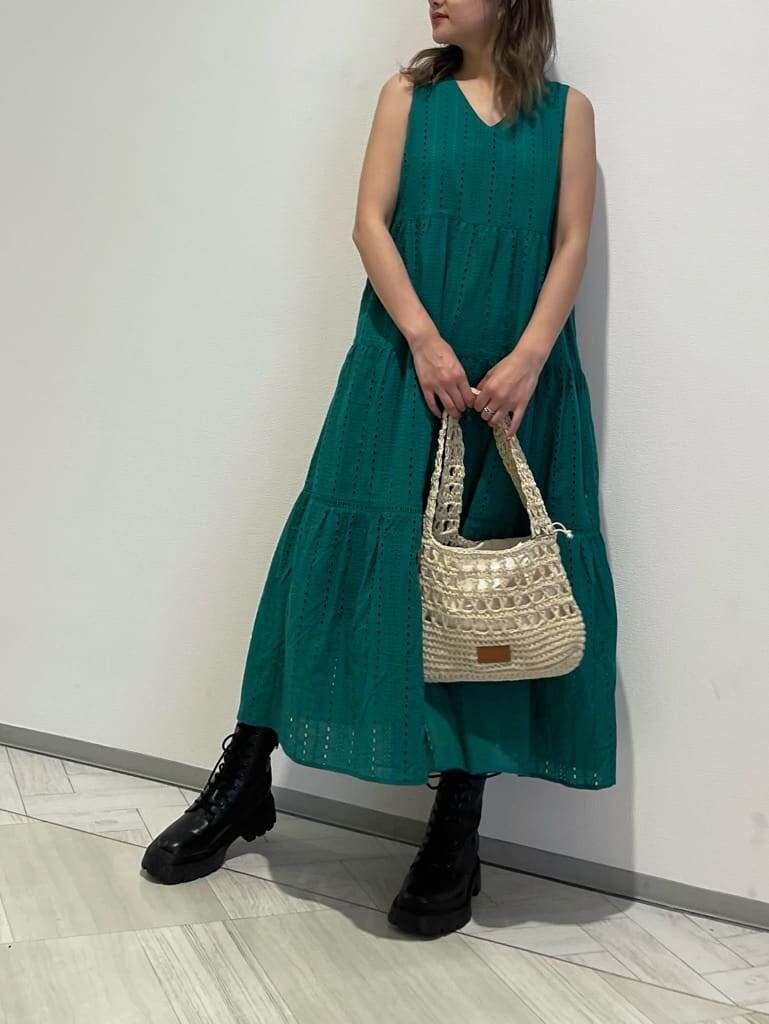 ブラック系のブーツ、グリーン系のワンピース、ベージュ系のショルダーバッグを着用したレディースの春コーディネートの3枚目の写真