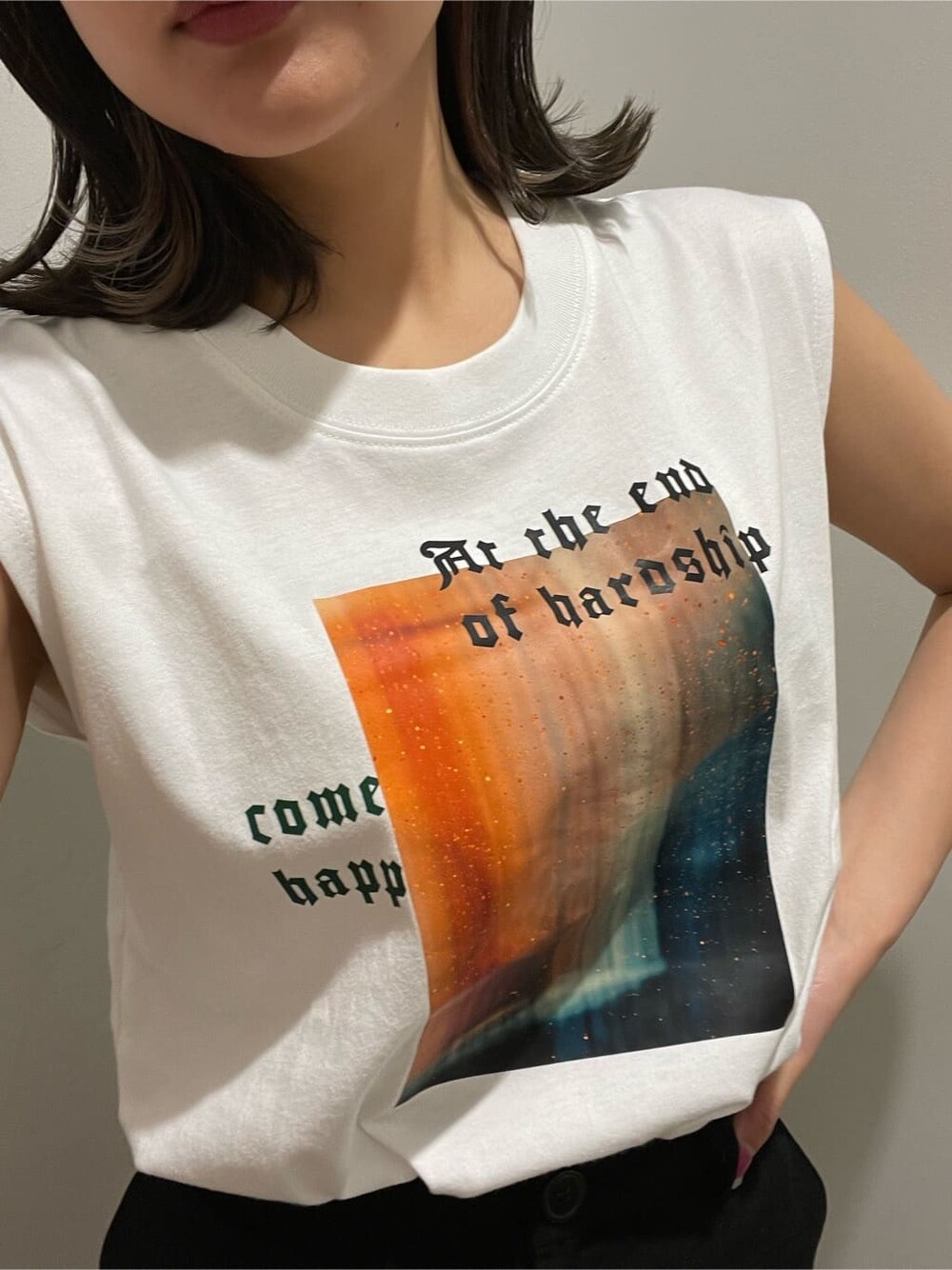 ブラック系のスカート、ホワイト系のTシャツ/カットソー、ブラック系のブーツを着用したレディースの春コーディネートの4枚目の写真