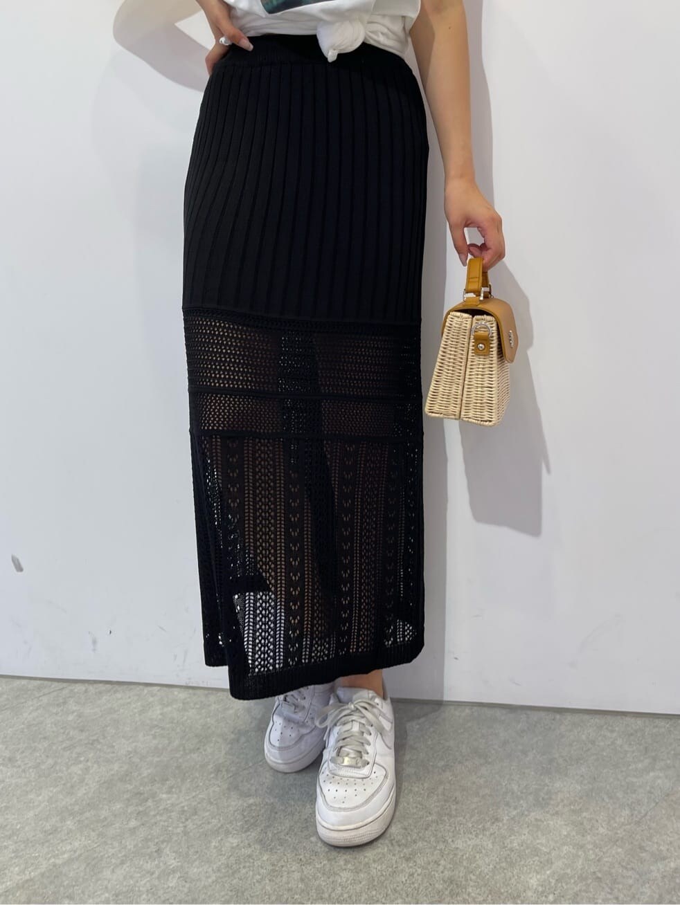 ホワイト系のTシャツ/カットソー、ブラック系のスカート、ベージュ系のショルダーバッグを着用したレディースの夏コーディネートの5枚目の写真