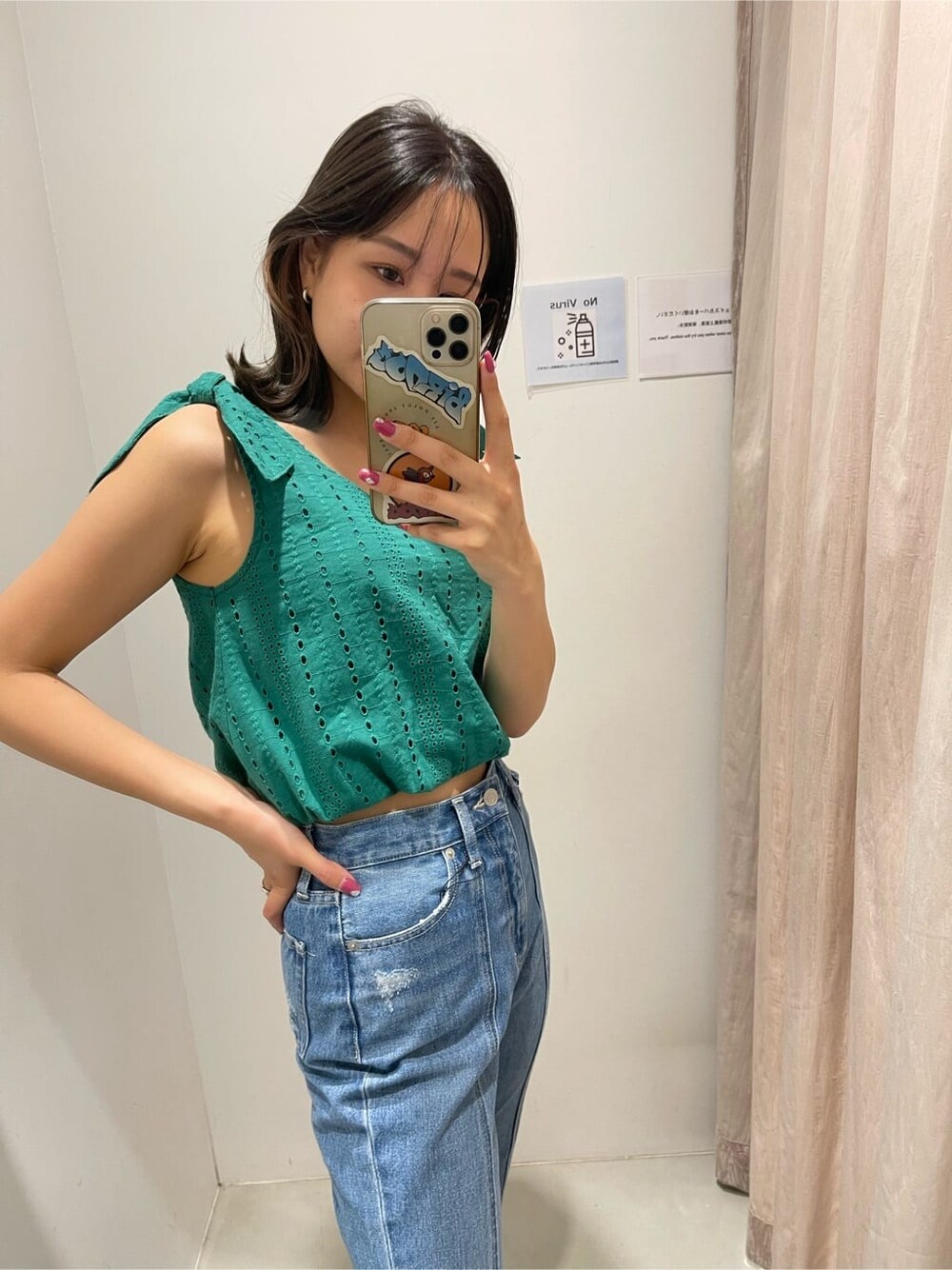 グリーン系のシャツ/ブラウス、ホワイト系のサンダル、ブルー系のデニムパンツを着用したレディースの春コーディネートの2枚目の写真