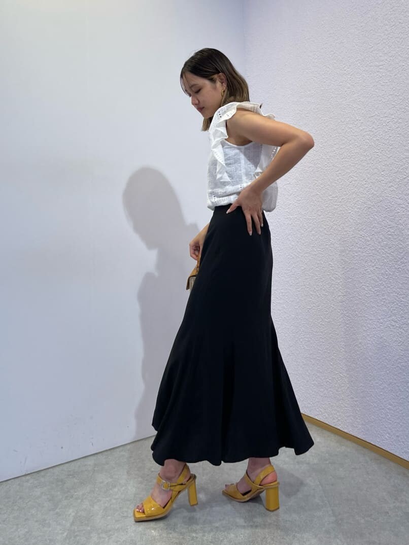 イエロー系のサンダル、ホワイト系のタンクトップ、ベージュ系のショルダーバッグを着用したレディースの夏コーディネートの4枚目の写真